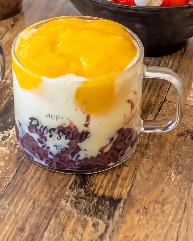 Mango Purple Rice Yoghurt in a glass mug: purple sticky rice, yoghurt and mango on top
